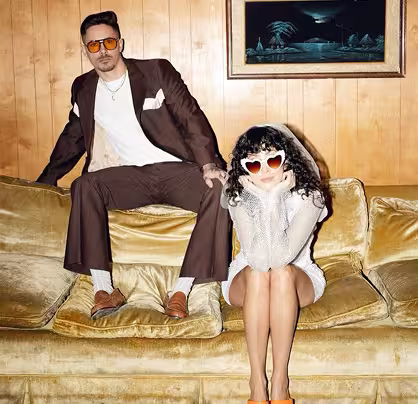 Pareja sobre sofá amarillo